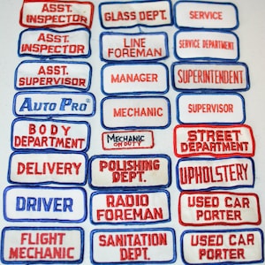 May include: A collection of 18 vintage embroidered patches with various job titles, including "Assistant Inspector", "Line Foreman", "Mechanic", "Street Department", "Upholstery", "Radio Foreman", and "Sanitation Dept.". The patches are white with red and blue lettering and borders.