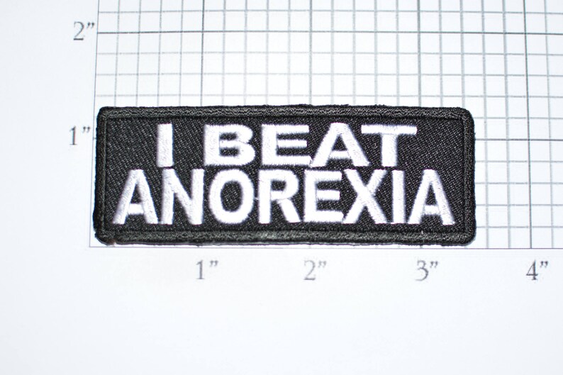 May include: Black embroidered patch with white text that reads "I BEAT ANOREXIA".