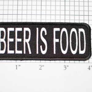 May include: Black embroidered patch with white text that reads "BEER IS FOOD".