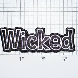 May include: Black and white embroidered patch with the word "Wicked" in a bold, stylized font.