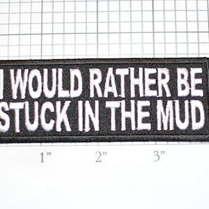 May include: Black embroidered patch with white text that reads "I would rather be stuck in the mud".