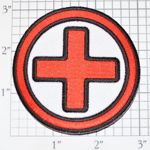 May include: Red embroidered medical cross patch with a white background and a black outline. The patch is 2 inches in diameter.