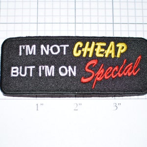 May include: Black embroidered patch with white text that reads "I'm not cheap but I'm on special" in red and yellow lettering.