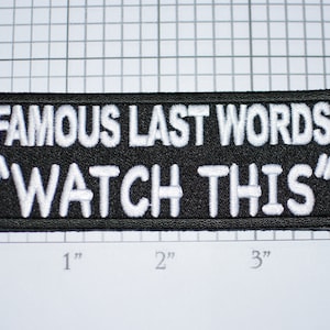 May include: Black embroidered patch with white text that reads "Famous Last Words "Watch This""