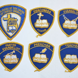 May include: Six blue and gold embroidered patches with different titles and images. The titles include "Soldiers of the Cross of Christ Church", "Deaconess", "Evangelist", "Pastor Evangelist", "Preacher", and "Teacher".
