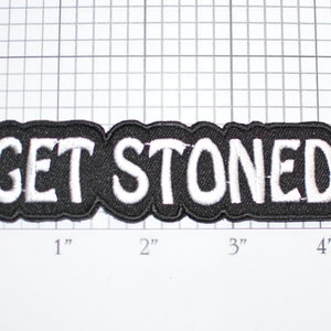 May include: Black iron-on patch with white embroidered text that reads "GET STONED".