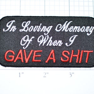 May include: Black embroidered patch with white text that reads "In Loving Memory Of When I GAVE A SHIT" in red.
