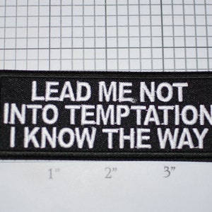 May include: Black embroidered patch with white text that reads "Lead me not into temptation I know the way".