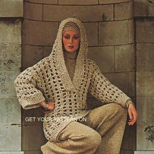 Puede incluir: Un suéter con capucha de crochet beige con un cuello alto y pantalones a juego. El suéter tiene un diseño de tejido abierto y mangas largas. El texto "GET YOUR PATTERN ON" es visible en la parte inferior de la imagen. El atuendo es de estilo vintage.