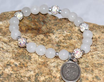 Pulsera elástica de selenita con dije "Ven Espíritu Santo" y detalles pavé brillantes.