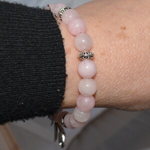 Op de afbeelding: Een armband van roze edelstenen met zilveren kralen en een zilveren sluiting.