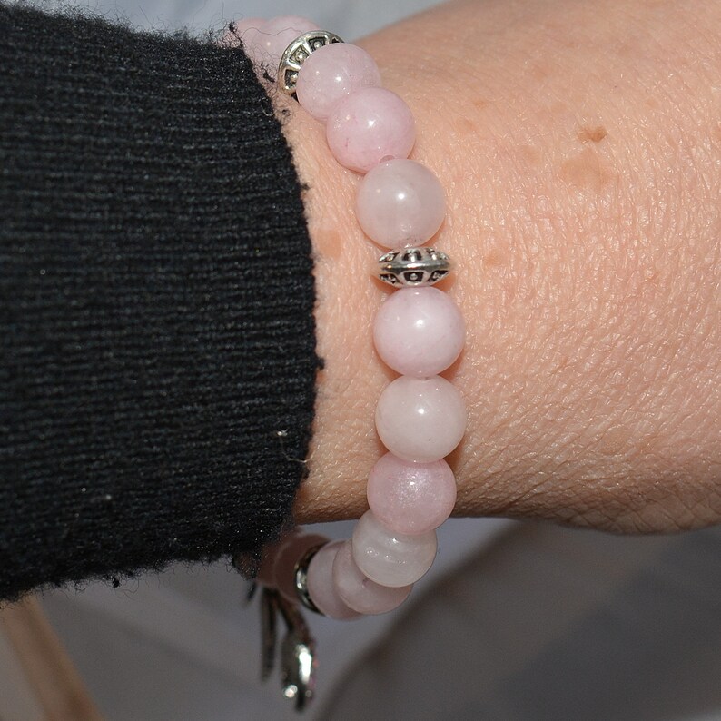 Op de afbeelding: Een armband van roze edelstenen met zilveren kralen en een zilveren sluiting.