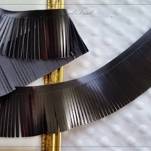 Puede incluir: Dos piezas de ribete de flecos negros. El fleco está hecho de tiras finas de cuero. El fleco tiene aproximadamente 2,5 cm de ancho.