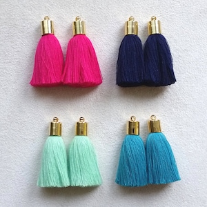 Puede incluir: Conjunto de ocho borlas de adorno en cuatro colores: rosa, azul, verde menta y turquesa. Cada borla tiene una parte superior dorada.