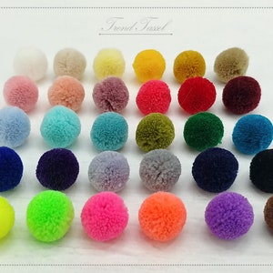 May include: Assortment of 30 colourful pom poms in various colours, including pink, blue, green, yellow, red, purple, orange, brown, and grey. The pom poms are arranged in rows on a white surface. "Trend Tassel" is written in black text at the top of the image.