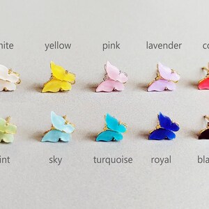 May include: A collection of butterfly-shaped accessories in various colors, including white, yellow, pink, lavender, coral, mint, sky blue, turquoise, royal blue, and black. Each butterfly has gold-colored accents.