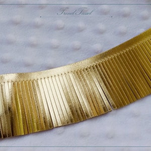 Puede incluir: Borde de flecos de cuero dorado. Los flecos tienen aproximadamente 2,5 cm de largo y están cosidos a una tira de cuero.