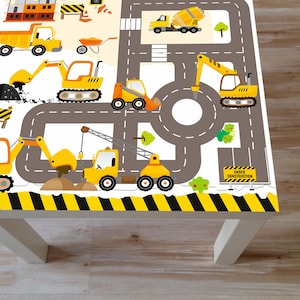 May include: A yellow and black construction themed table cover with a road and various construction vehicles, including a dump truck, excavator, crane, and bulldozer. The table cover has a sign that says "Under Construction".