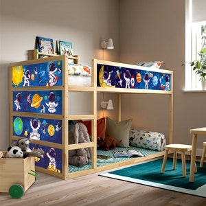 May include: A wooden bunk bed with a space-themed design. The bed features a blue background with planets, stars, and astronauts. The bed is made of natural wood and has a ladder on the side.