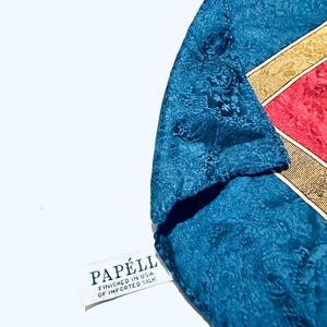 Puede incluir: Un pa&ntilde;uelo de seda azul con un borde estampado en oro y rojo. El pa&ntilde;uelo tiene una etiqueta blanca que dice "Papell, Finished in USA of Imported Silk."