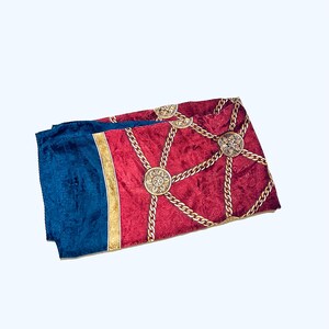 Puede incluir: Un pa&ntilde;uelo de seda rojo y azul con un patr&oacute;n de cadena y medall&oacute;n dorado.