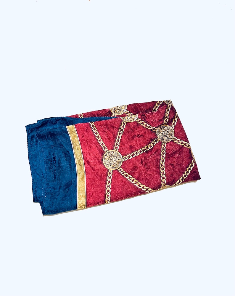 Puede incluir: Un pa&ntilde;uelo de seda rojo y azul con un patr&oacute;n de cadena y medall&oacute;n dorado.