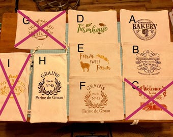 May include: Nine beige fabric bags with different designs printed on them. The designs include "Fresh Baked Bread", "Farm Sweet Farm", "Grains Type de N°45 Farine de Gruau", "Homemade Bakery", "Welcome to our Farmhouse", and "Patisserie & Confiserie Specialite de Patience Marque de Fabrique".