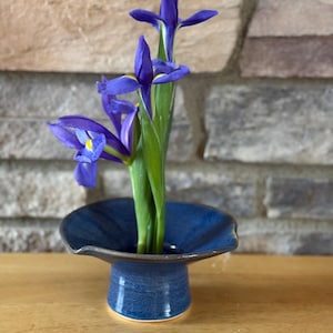 May include: A set of three ceramic mugs with a speckled, matte finish. The mugs are in shades of cream, light gray, and dark gray. Each mug has a simple, minimalist design, perfect for coffee or tea.