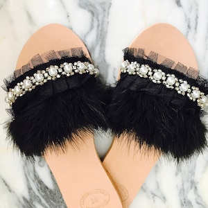 Pu&ograve; includere: Sandali neri con piume e perle decorate con una suola in pelle. I sandali hanno un bordo in tulle nero e sono taglia 38.