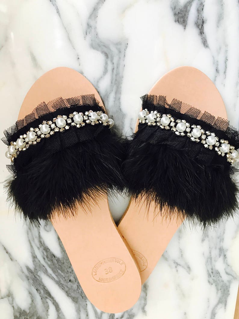 Pu&ograve; includere: Sandali neri con piume e perle decorate con una suola in pelle. I sandali hanno un bordo in tulle nero e sono taglia 38.