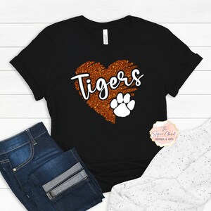 May include: Black t-shirt with a glittery orange heart that says "Tigers" with a white paw print inside the heart.