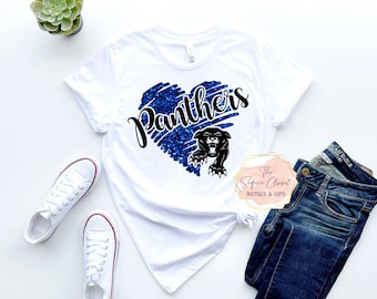 May include: White t-shirt with a blue glitter heart design that says "Panthers" in black text. A black panther silhouette is inside the heart.