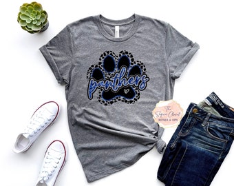 May include: Gray t-shirt with a black paw print design and the word "panthers" in blue glitter. The paw print has a blue glitter outline.