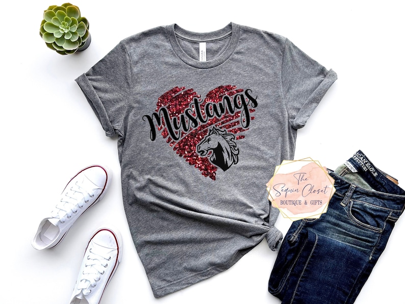 May include: Gray t-shirt with a red glitter heart that says "Mustangs" with a black horse silhouette inside the heart.