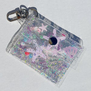 Ravissante pochette en vinyle transparent avec remplissage sirène et paillettes - Parfaite pour ranger vos essentiels avec style !