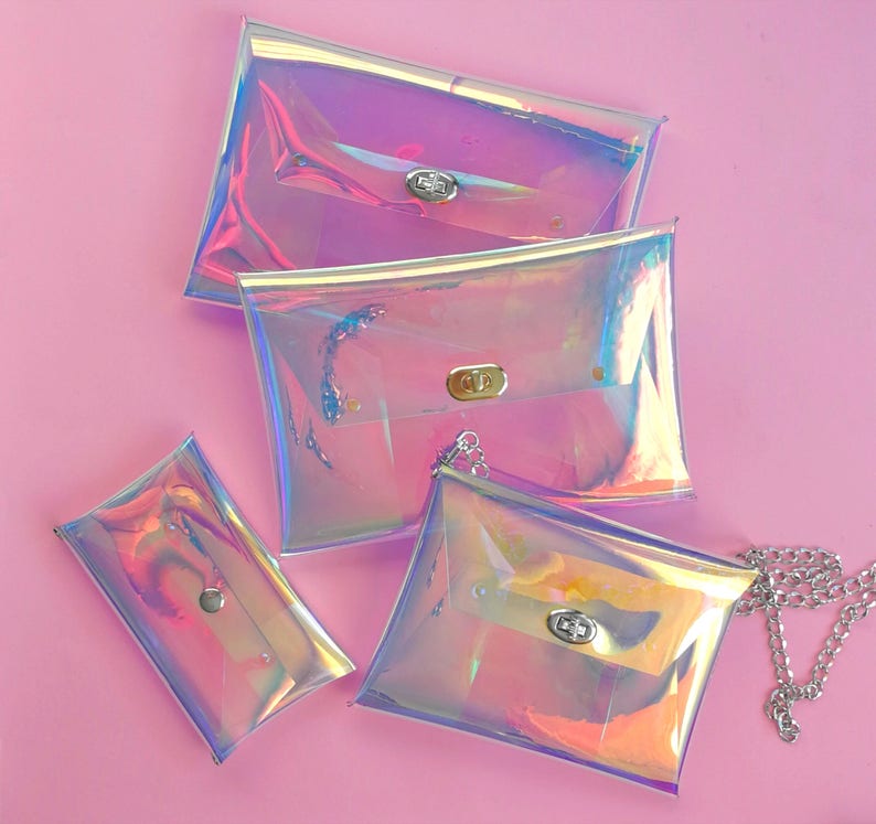May include: Four iridescent clear plastic bags with silver clasps. The bags are different sizes and one has a silver chain attached.