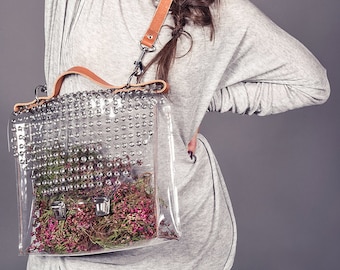 Borsa a tracolla in vinile trasparente: cinturino in pelle color caramello, occhielli industriali