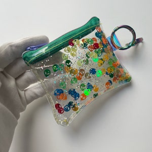 Cartera con cabeza de extraterrestre: compacta, elegante y práctica para tarjetas, efectivo y llaves. Hecha a mano con nostalgia y amor. Brillo colorido de los años 90.