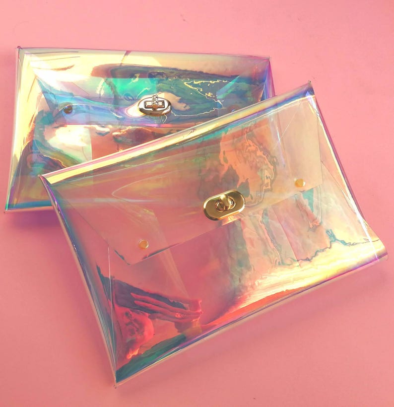 May include: Two iridescent clear plastic clutch purses with gold clasps. The purses are stacked on top of each other.