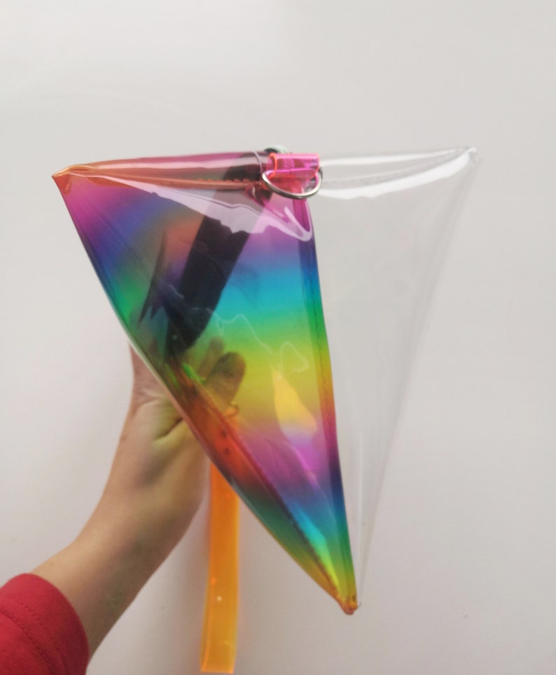 May include: A clear plastic rainbow iridescent pouch with a zipper closure and a yellow strap.