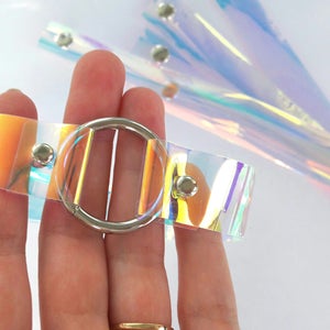 May include: A clear iridescent plastic belt with a silver metal buckle. The belt is adjustable and has a modern, futuristic look.