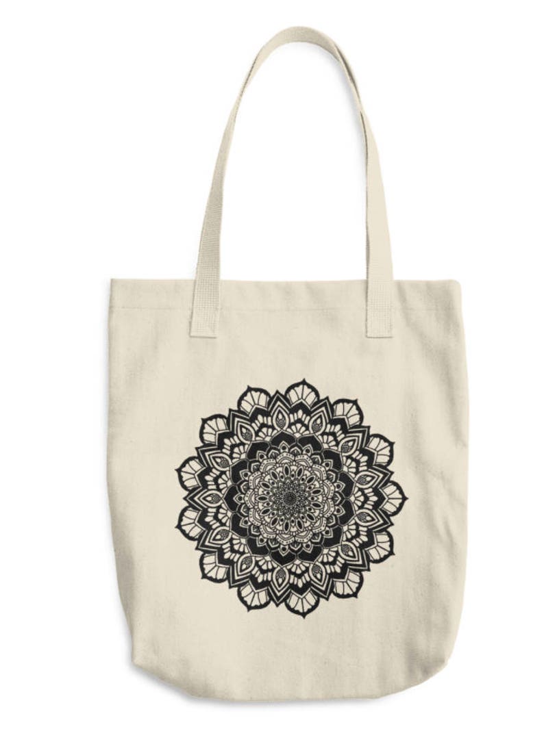 May include: A beige canvas tote bag with a black and white mandala design printed on the front.