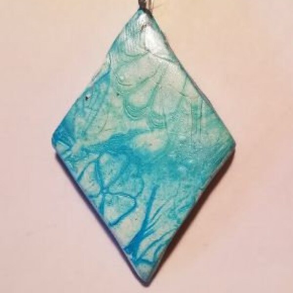 Faux# porcelain pendant, 2.3" long. Stamped and colored back, wax finish.