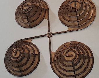 May include: A wooden game board with four circular playing areas. Each area has concentric circles with small holes around the outer edge. The board is connected by four arms that form a cross shape.