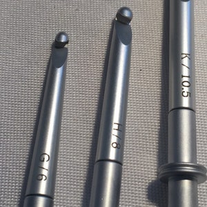 May include: Three silver crochet hooks with different sizes: G/6, H/8, and K/10.5.