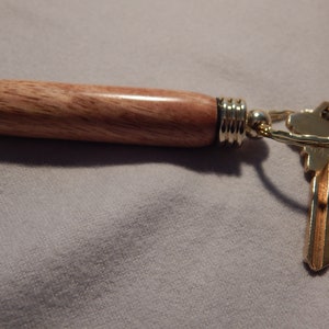 Multi-function key ring with secret compartment. Use as Toothpick, needle, or pill case, choice of wood or acrylic, purse or pocket sized