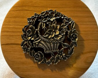 A wooden potpourri bowl with an antique pewter flower basket lid. Made from maple wood.