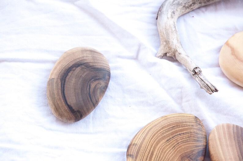 May include: Four wooden coasters with a natural wood grain pattern. The coasters are round and have a smooth, polished finish.