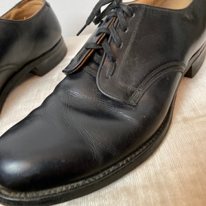 May include: A pair of black leather lace-up shoes with a rounded toe and a low heel.