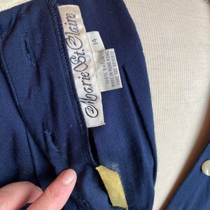 May include: A navy blue dress with a white collar and a white label that says "Monique St. Claire" and "100% Rayon Made in Hong Kong Care See Reverse 14".